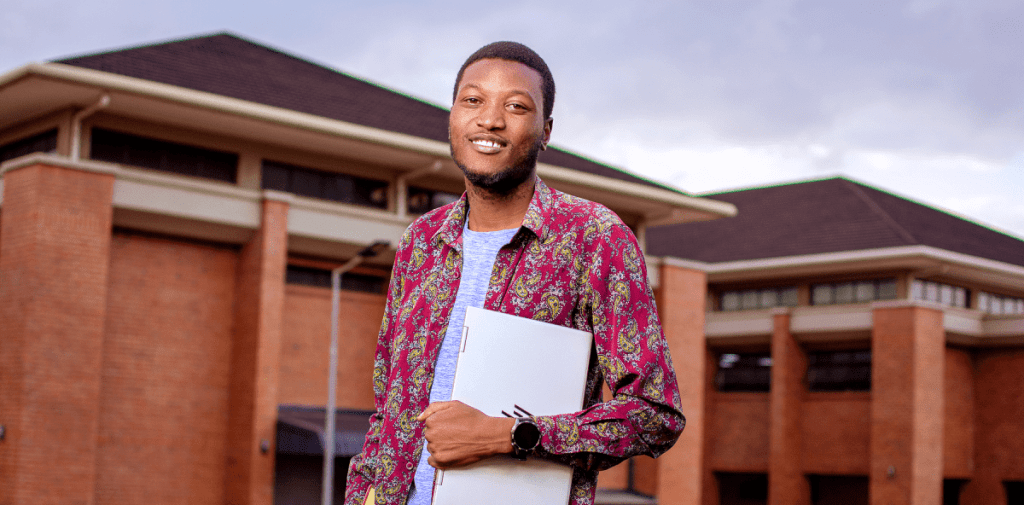 Student studying holding a laptop, representing flexible online learning opportunities.